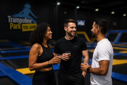 collaborateurs discutant autour d'un verre dans une salle de trampolines