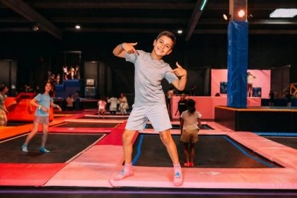 un garçon pose devant les trampolines dans un park indoor