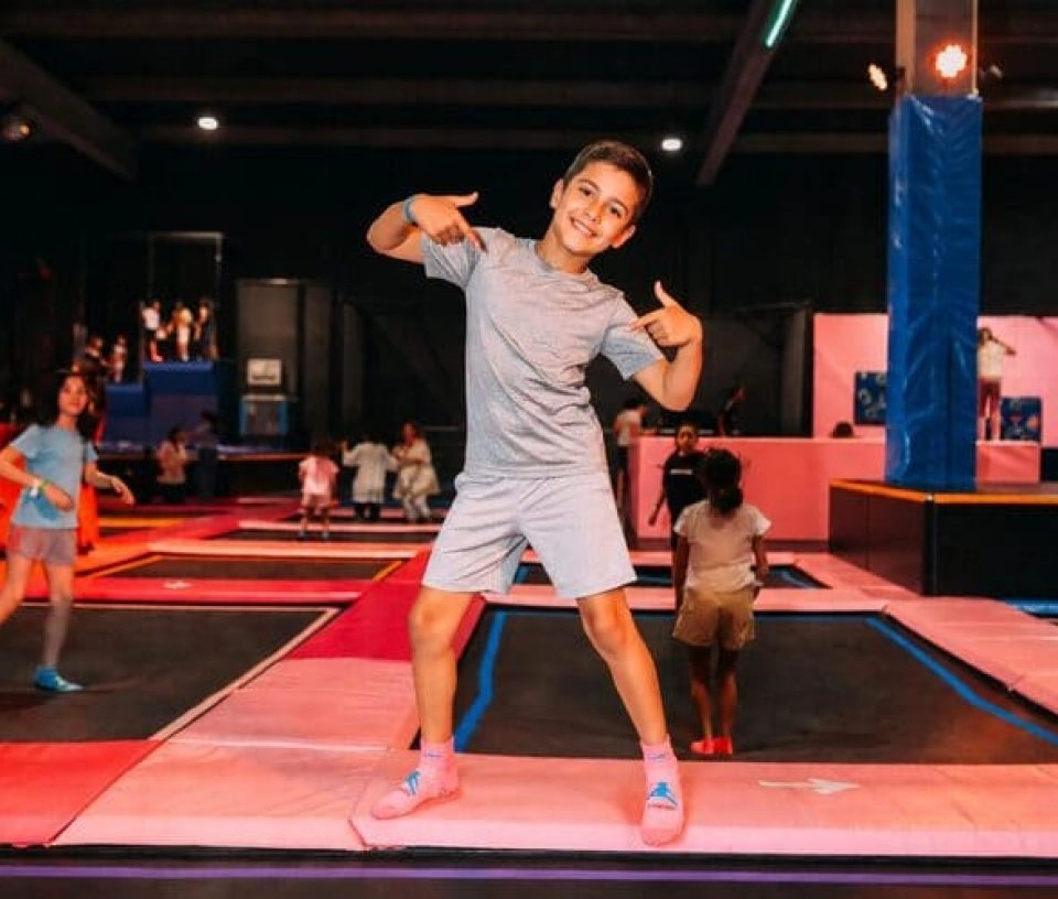 un garçon pose devant les trampolines dans un park indoor