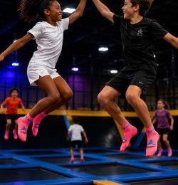 check dans les airs entres copains dans un trampoline park (portrait)