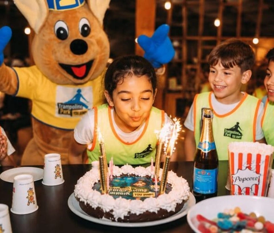 une fille souffle ses bougies lors de son anniversaire chez trampoline park